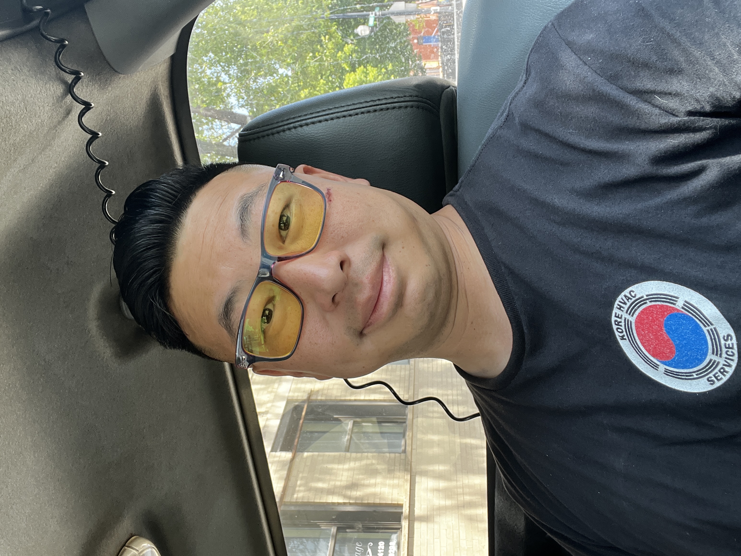 Craig Kalinowski in his van wearing yellow glasses and a Kore HVAC Services shirt